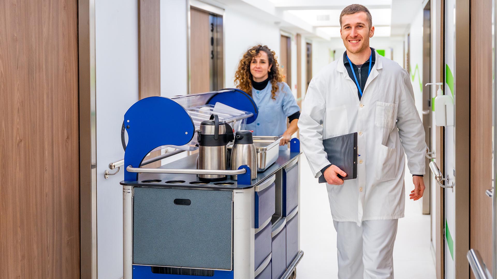 Doctor next to a nurse with a trolley with coffee